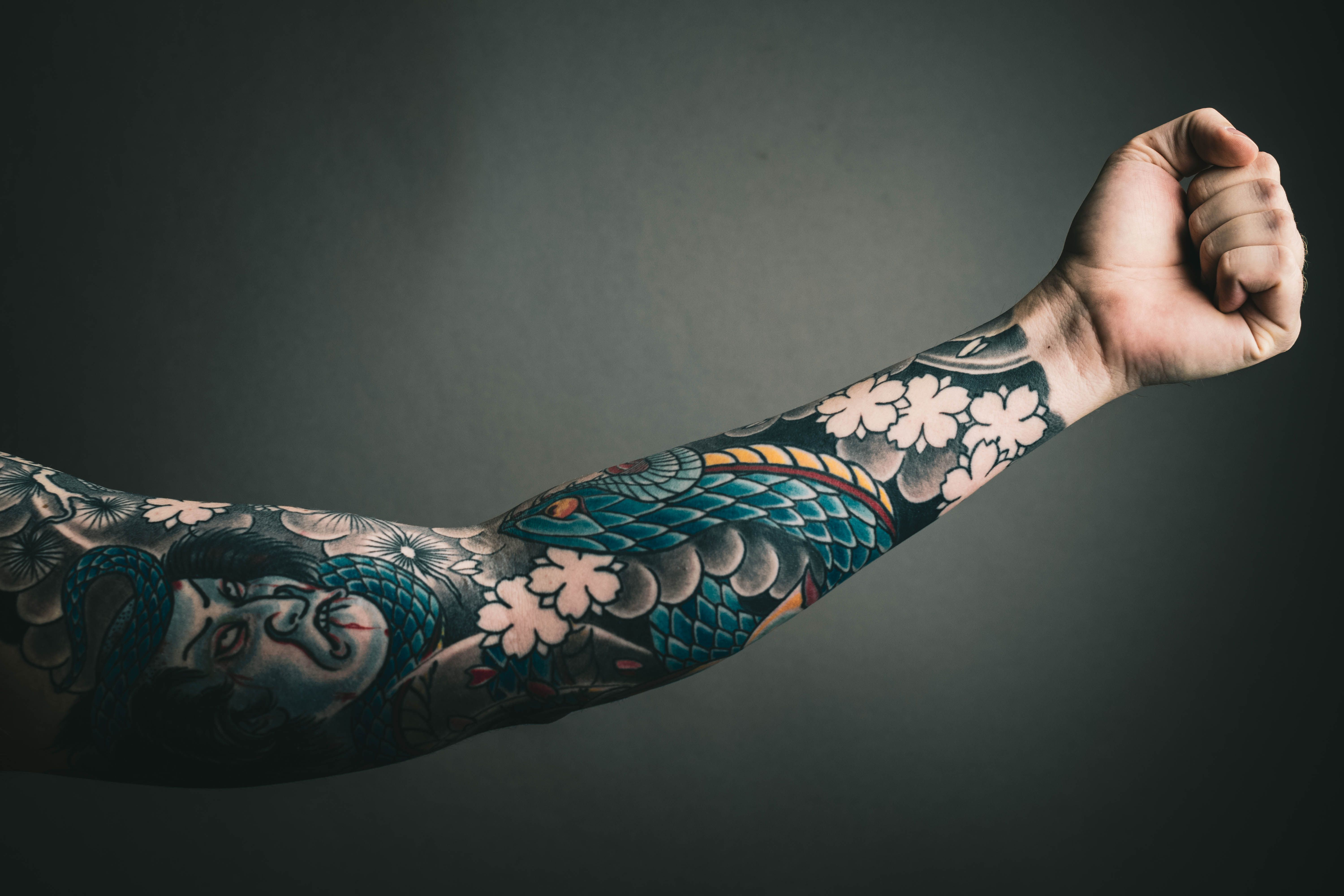 Tatuador aplicando tatuagem colorida